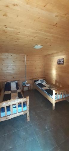 Habitación con 2 camas en una cabaña de madera en Drinski Mir, en Mali Zvornik