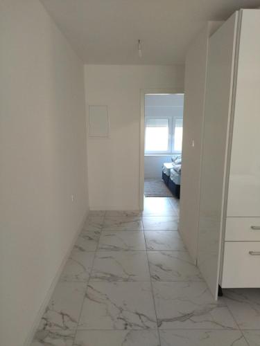 an empty room with white walls and a marble floor at Ivan apartmani Posušje in Posušje