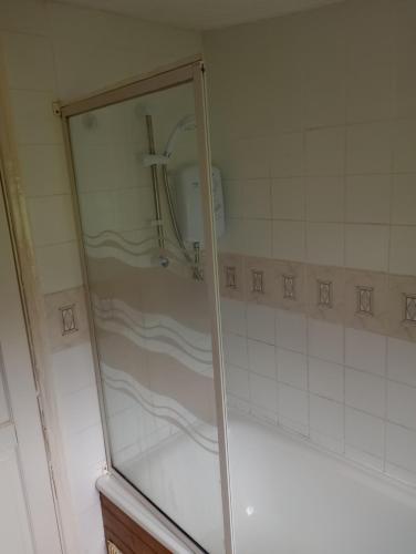 a shower with a glass door in a bathroom at Sea views in Bideford