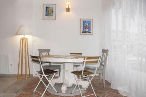 une salle à manger avec une table et des chaises blanches dans l'établissement Sète: Magnifique appartement 8 couchages, à Sète