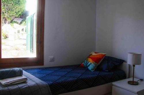 a bedroom with a bed with a pillow and a window at Biniplaya - Apartamento reformado al lado de la playa in Arenal d'en Castell