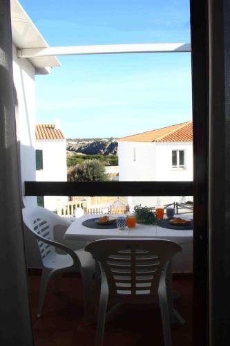 a table and chairs on a balcony with a view at Biniplaya - Apartamento reformado al lado de la playa in Arenal d'en Castell