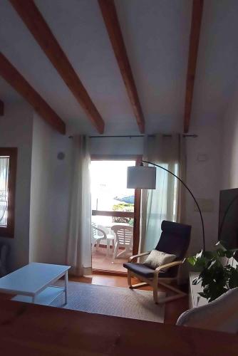 a living room with a chair and a table at Biniplaya - Apartamento reformado al lado de la playa in Arenal d'en Castell
