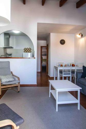 a living room with a couch and a table at Biniplaya - Apartamento reformado al lado de la playa in Arenal d'en Castell