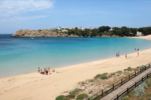a group of people on a beach near the water at Biniplaya - Apartamento reformado al lado de la playa in Arenal d'en Castell