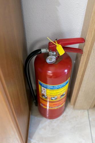 a fire extinguisher is sitting next to a wall at Stavroula's Houses in Kélla