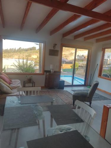 ein Wohnzimmer mit Sofas, Tischen und einem Pool in der Unterkunft Linda cabaña interior con piscina y entrada independiente en concon in Concón