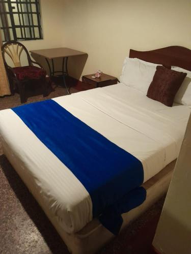 a blue and white bed in a room at Tim Times Ltd self contained rooms in Nairobi