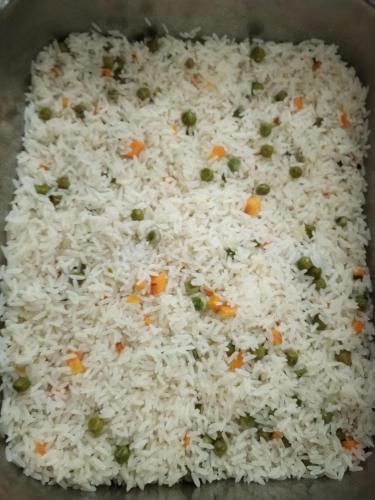 a pan of rice with peas and carrots at Tim Times Ltd self contained rooms in Nairobi