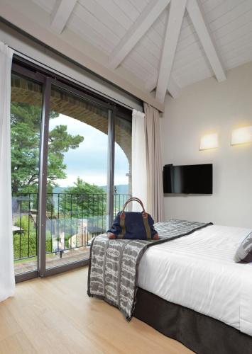 a bedroom with a bed and a large window at Relais San Maurizio in Santo Stefano Belbo