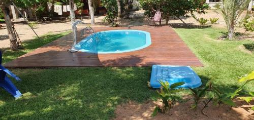 una pequeña piscina en un patio con terraza de madera en TrevizZo Genipabu Natal!, en Natal