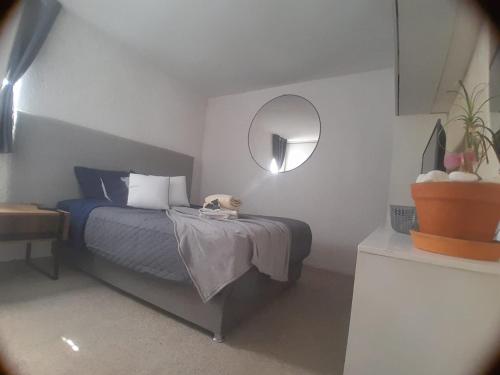 a bedroom with a bed and a round mirror at Casa Bosques in Cuautitlán Izcalli