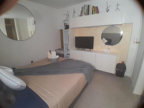a small bedroom with a bed and a mirror at Casa Bosques in Cuautitlán Izcalli