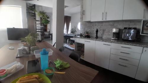 a kitchen with a wooden table and white cabinets at Casa Bosques in Cuautitlán Izcalli