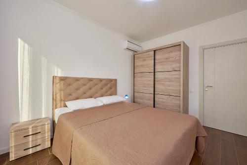 a bedroom with a large bed and a closet at Adria lux apartmens 2 in Sveti Stefan