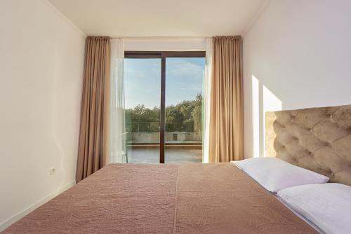 a bedroom with a bed and a large window at Adria lux apartmens 2 in Sveti Stefan