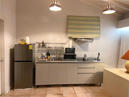 eine Küche mit einem Kühlschrank und einer Mikrowelle in der Unterkunft Cacao Luxury Suite in Coronado in Chame