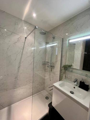 une salle de bain blanche avec une douche et un lavabo dans l'établissement T1bis vue mer et port Marina Baie des Anges, à Villeneuve-Loubet