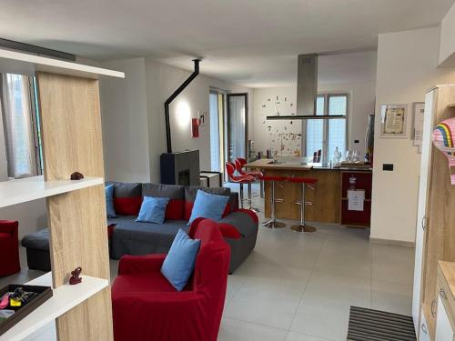 sala de estar con sofá rojo y cocina en Casa Varisco: Oasis of peace surrounded by nature., en Faggeto Lario 