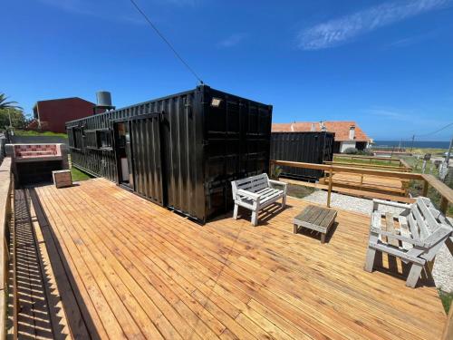 a deck with benches and a black shipping container at Apart Containers, Acantilados, unidad in Mar del Plata