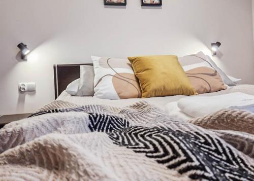 a bed with a zebra blanket and pillows on it at Apartamenty na Wyspie - Villa Mistral - Apartamenty z sypialnią i parkingiem in Świnoujście