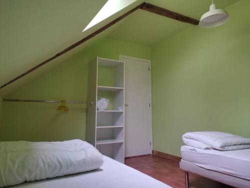 Zimmer mit 2 Betten und einer grünen Wand in der Unterkunft Longère chaleureuse et familiale - 3 chambres in Limerzel