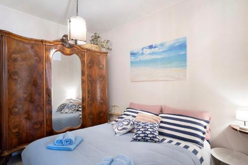 - une chambre avec un lit et un grand miroir dans l'établissement Gli Orti sul mare 1, à Bordighera