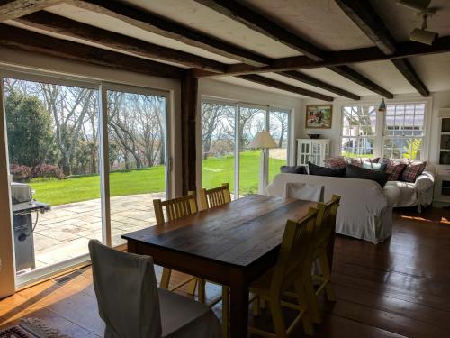 een woonkamer met een houten tafel en stoelen bij Chatham Family retreat:Tennis,water views&access! in Chatham