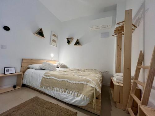 a bedroom with white walls and a bed and a ladder at Niña Mala in Valencia