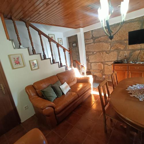 a living room with a leather couch and stairs at Quinta das Amendoeiras in Meda
