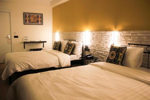 a hotel room with two beds and a brick wall at THINK HOTEL in Konya