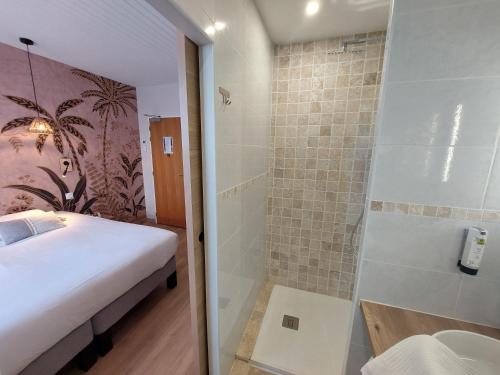 een badkamer met een douche, een bed en een wastafel bij Logis Hôtels - Hôtel et Restaurant Les Voyageurs in Tournon-dʼAgenais