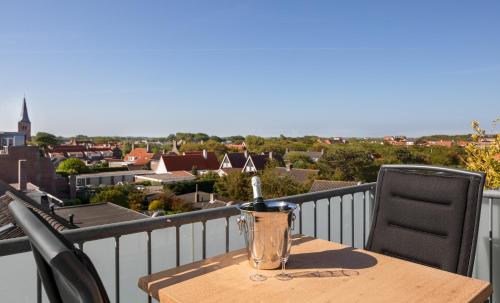 a table and chairs on a balcony with a view at Strandhotel Domburg - Next Door in Domburg