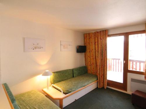 een hotelkamer met een groene bank en een raam bij Appartement cosy 4 pers, navette proche, balcon - Alpe d'Huez - FR-1-405-166 in Huez