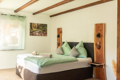 a bedroom with a bed with green pillows at Rhön & Relax in Wildflecken