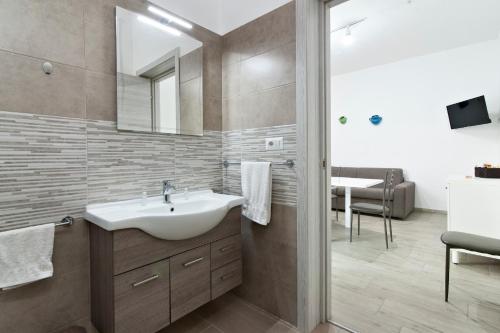 uma casa de banho com um lavatório e um espelho em ASZ APARTMENTS em Torre Lapillo