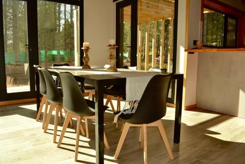 圣马丁德洛斯Chapelco Golf - Cabaña a Estrenar的餐厅里有一张桌子和几把椅子