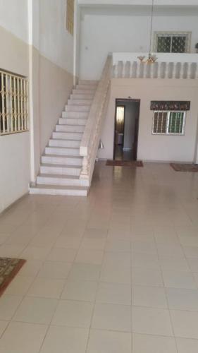 een grote kamer met een trap en een witte vloer bij #4 princess self catering apartments, Senegambia area in Sere Kunda