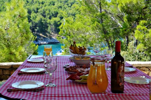 einen Picknicktisch mit einer Flasche Wein und Gläsern in der Unterkunft Poseidon Holiday House in Milna