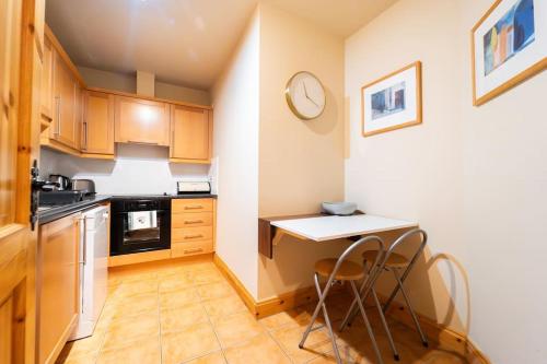 a small kitchen with a table and two chairs at Central Dingle Stay in Dingle