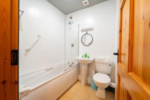 Central Dingle Stay في دينغل: حمام ابيض مع مرحاض ومغسلة