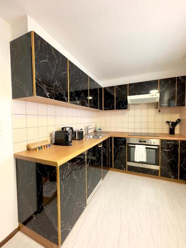 a kitchen with black marble cabinets and a counter at Charmante Wohnung am Hafen in Bregenz