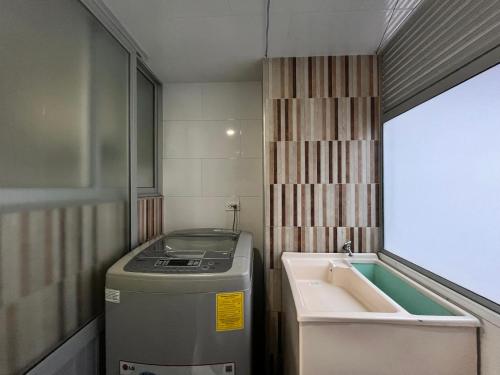 a small kitchen with a sink and a washing machine at Confort 301 Apartamento Duitama in Duitama