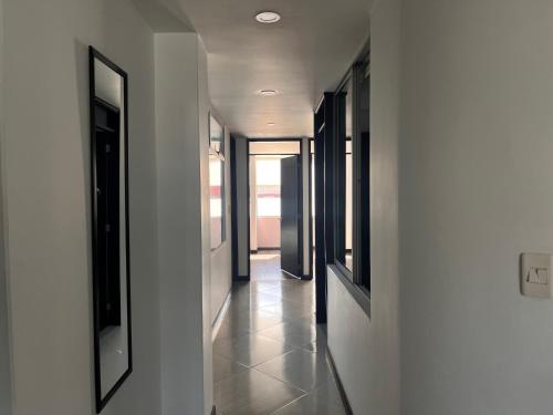 a hallway of a house with white walls and windows at Confort 301 Apartamento Duitama in Duitama