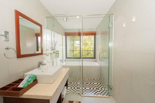 een badkamer met een wastafel en een glazen douche bij 4BR Villa Near The Beach & Shared Pool in Phu Quoc