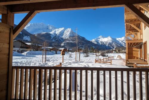 - une vue sur les montagnes enneigées depuis la terrasse couverte d'une cabine dans l'établissement Le Polaris à 7mn à pieds des pistes - 100m2 garage, au Monêtier-les-Bains