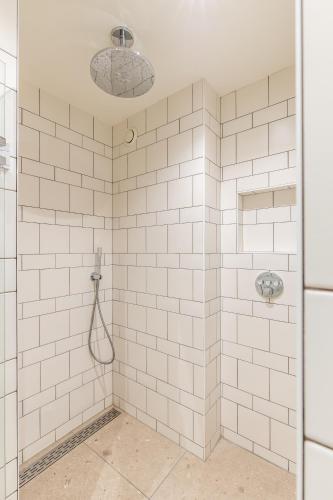 a bathroom with a shower with white tiles at Strandhotel Domburg - Next Door in Domburg