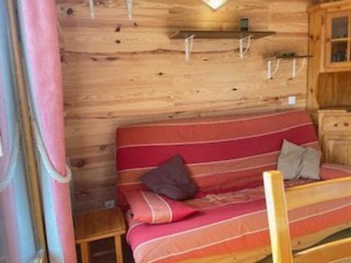 - un canapé dans une chambre dotée d'un mur en bois dans l'établissement Appartement Risoul, 2 pièces, 6 personnes - FR-1-330-553, à Risoul