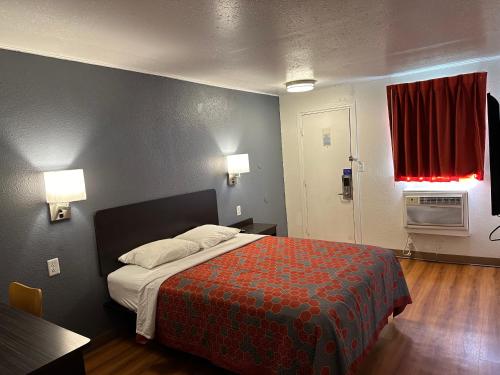 - une chambre avec un lit et une couverture rouge dans l'établissement Sullivan Inn, à Sullivan