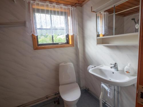 a bathroom with a sink and a toilet and a window at Högerödja in Hultsfred